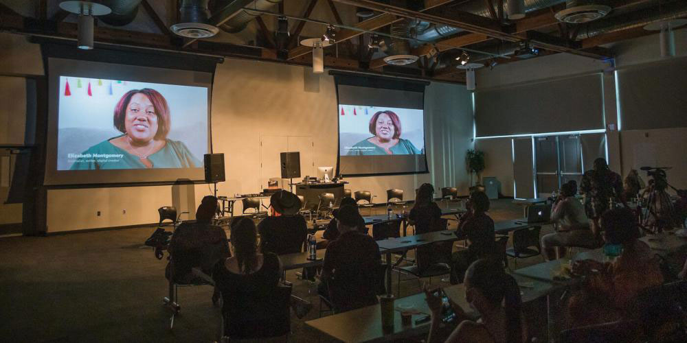 Photo of film screens with attendees